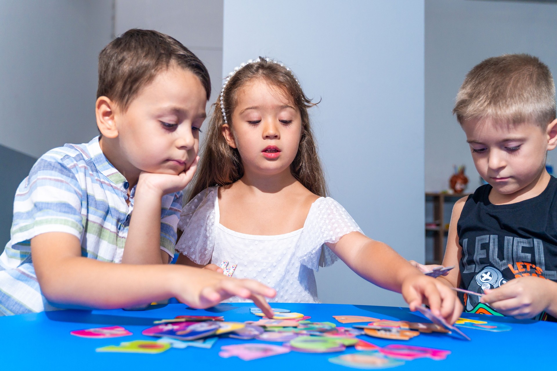 Preschool-aged children immerse themselves in captivating tasks, solving logic puzzles, and refining fine motor skills during engaging developmental sessions. Kids studying in classroom